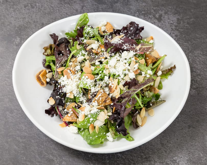 Fresh mixed greens salad topped with feta, almonds, and dried figs.